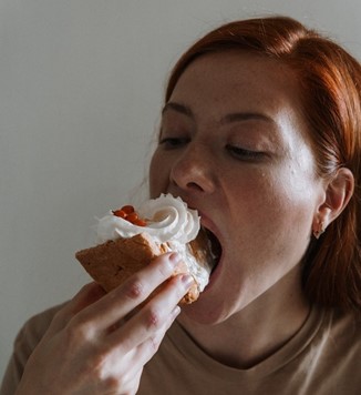 a woman shoving cake into her face