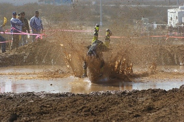 An overconfident motocross rider crashing into the mud