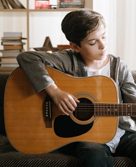 A boy learning guitar