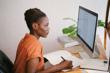 A woman confidently studying at a computer