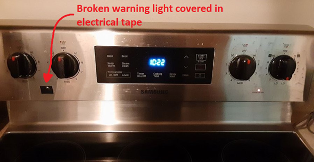 Our stovetop showing the light that works and the broken light covered in electrical tape