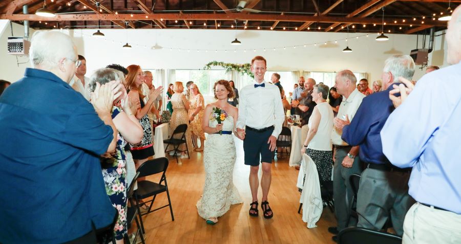 My wife and I walking down the aisle after the ceremony, surrounded by friends and family.