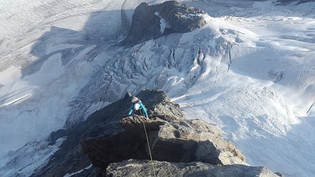 A mountaineer climbing a dangerous ridge