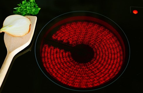 A red-hot burner on a ceramic stovetop