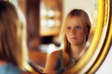 A woman looking at herself in the mirror