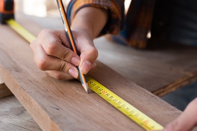 a carpenter carefully measuring a board