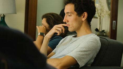 a guy on a couch lost in thought ignoring the person next to them