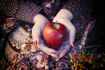 a red apple being held in someone's hands