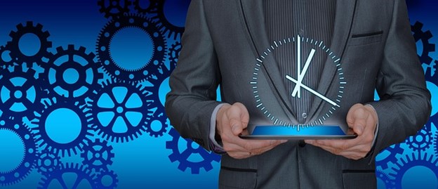 a man in a suit holding a tablet with a clock symbol above it and gears in the background