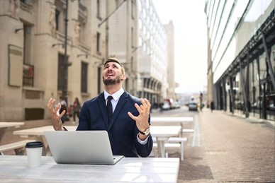 a man at a laptop looking very frustrated