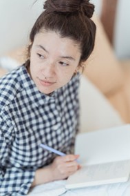 a woman pridefully reflecting on what she's done in a journal