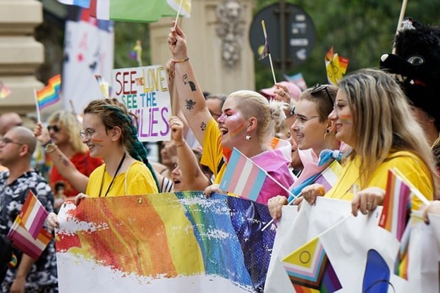 A group of smiling people decked out in rainbows at an LGBTQ pride parade