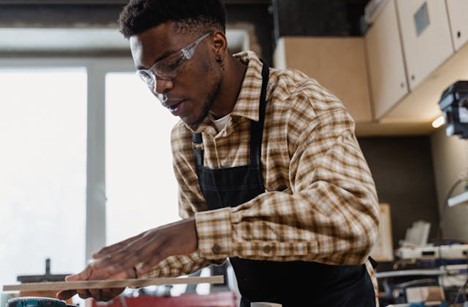 a young man focused on his work in a carpentry shop