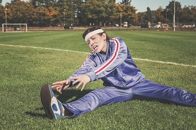 a person in exercise gear struggling to touch their toes