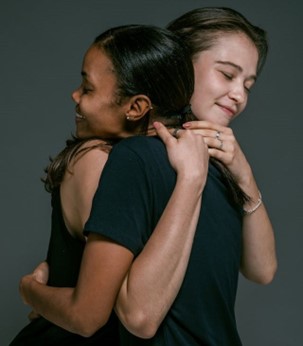 Two women hugging each other