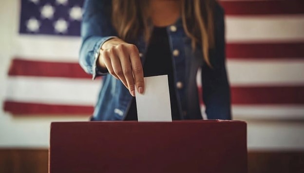 a woman putting her vote in a ballot box