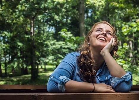 A hopeful person looking up and smiling