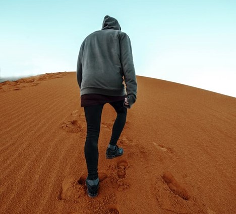 a lone man walking in the desert