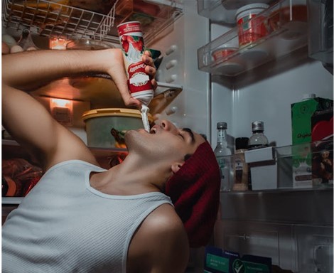 A man eating whipped cream straight from the can