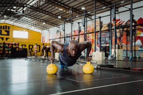 an older man doing pushups in a gym