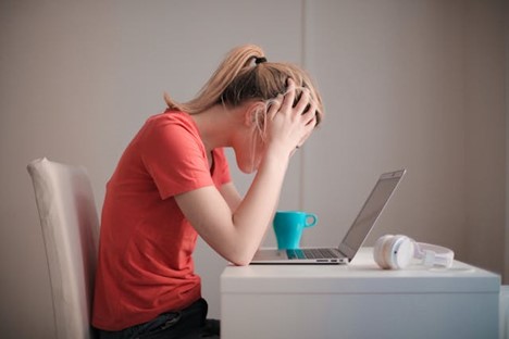 a frustrated person staring at a laptop