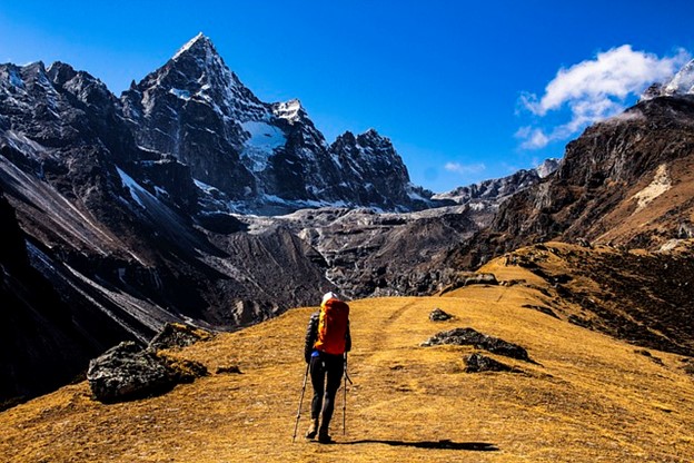 someone hiking in the mountains with boots and trekking poles