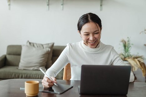 A woman happily working at her desk
