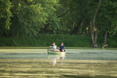 a father and son fishing in a canoe