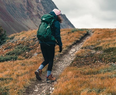 a hiker nearing the top of a hill