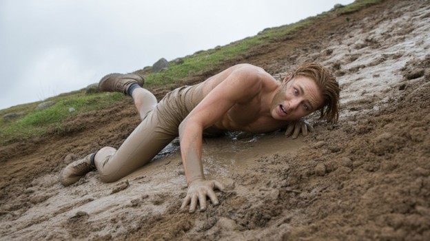 a man who has slipped and fallen on a muddy hillside