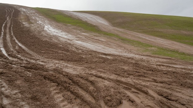 a muddy hillside that gets flatter at the top