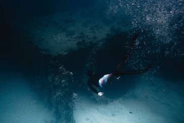a scuba diver going deeper