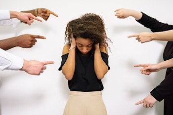 people pointing their fingers at an ashamed woman