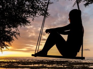 A person deep in thought watching a sunset