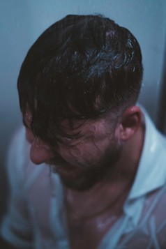 a drenched man looking very unhappy